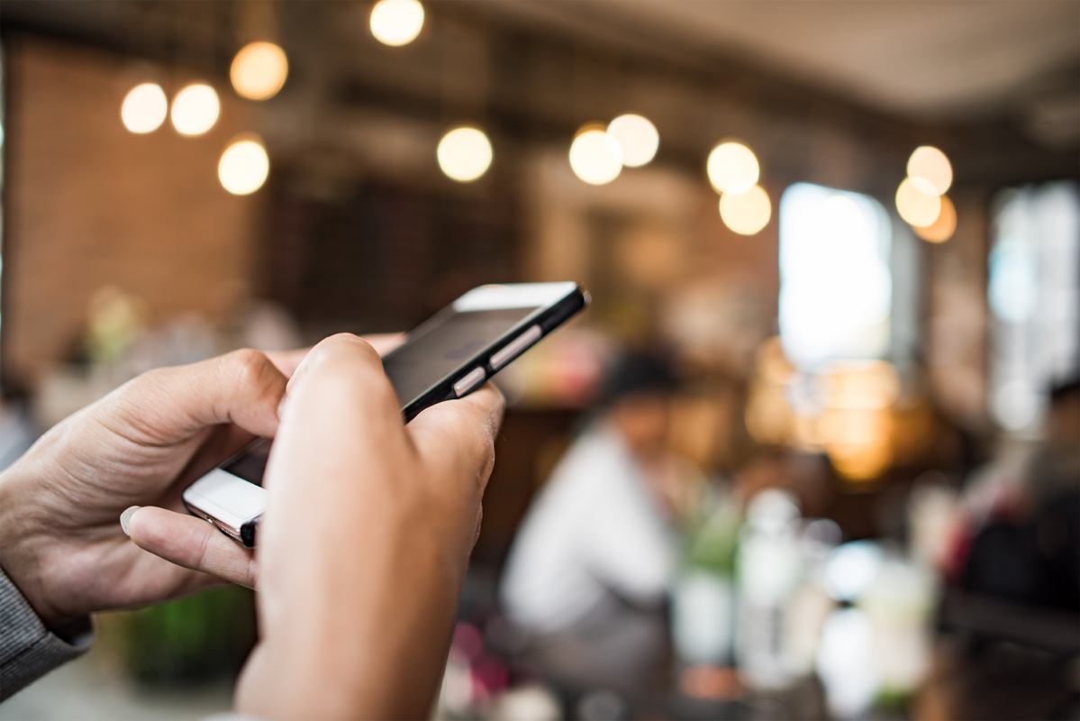 Close-up of hands using the Hyfin mobile payment app to process a secure digital transaction in a business environment